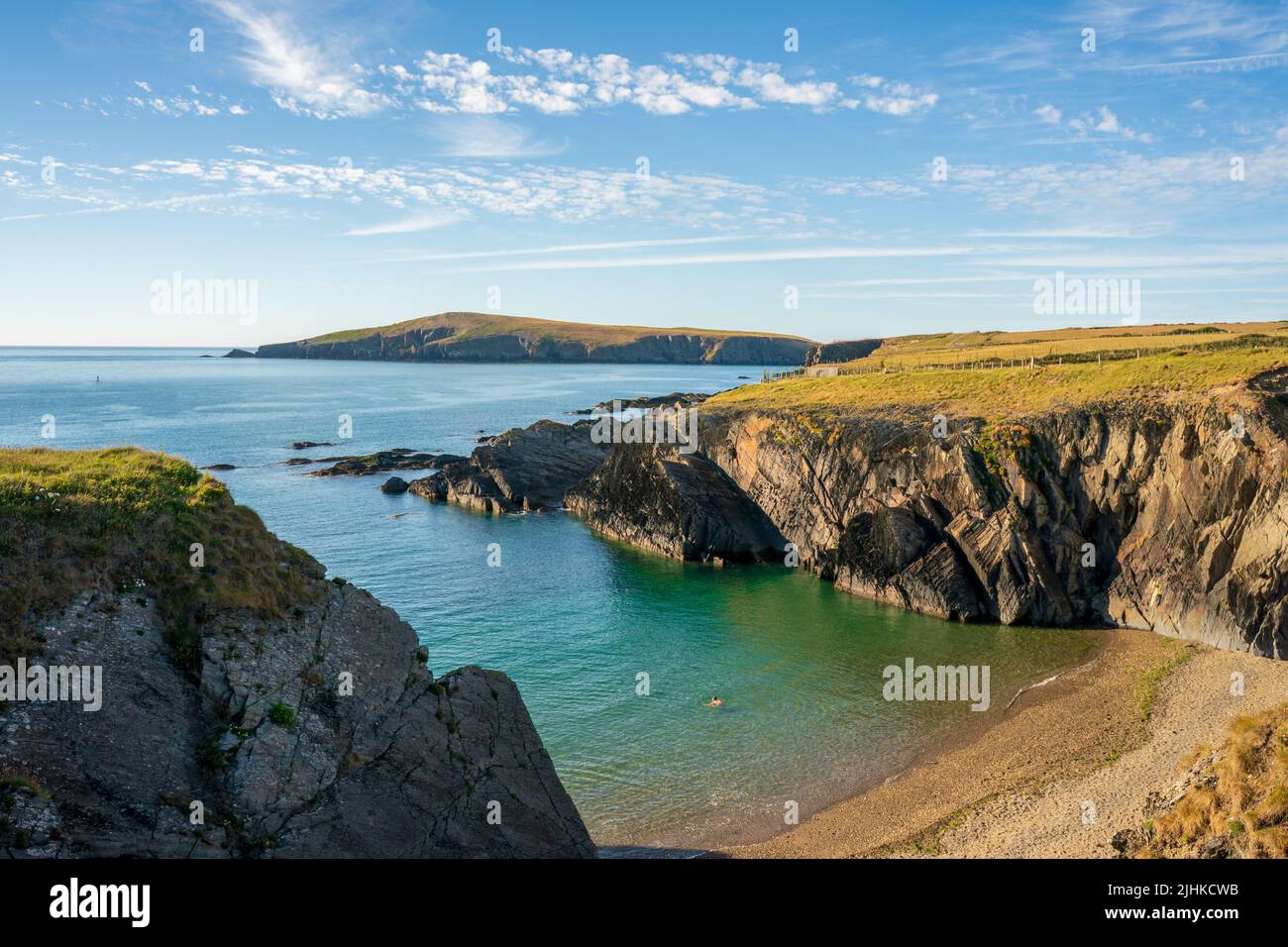 Una vista paesaggistica della costa della baia di cardigan con l'isola in lontananza nel Galles Occidentale Foto Stock