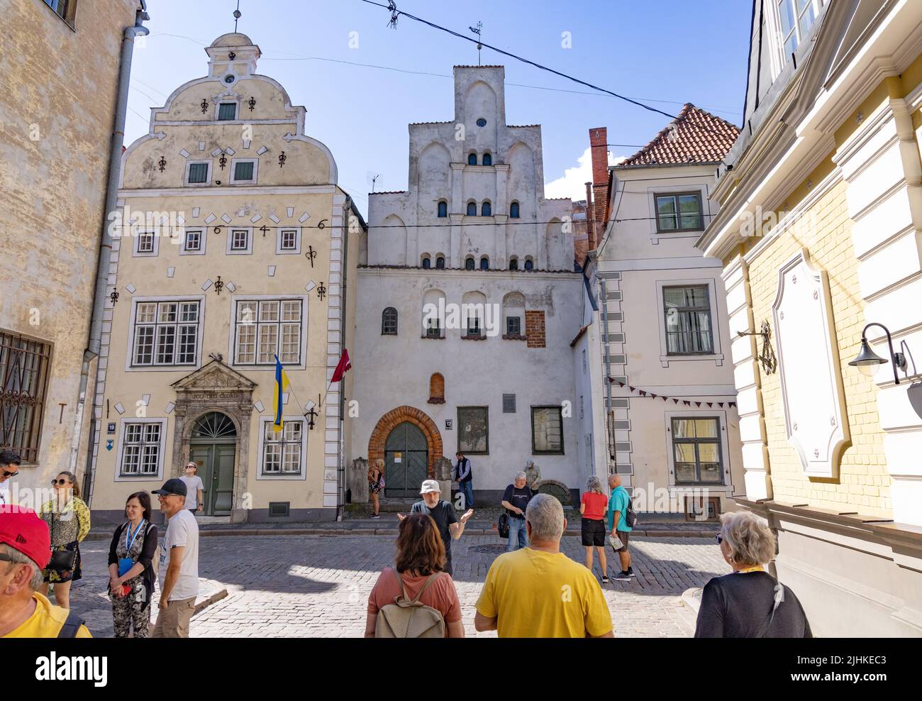 Turisti riga Lettonia viaggio; persone che guardano una fila di edifici medievali, noti come i tre Fratelli, in estate, riga Città Vecchia, riga Lettonia Europa Foto Stock
