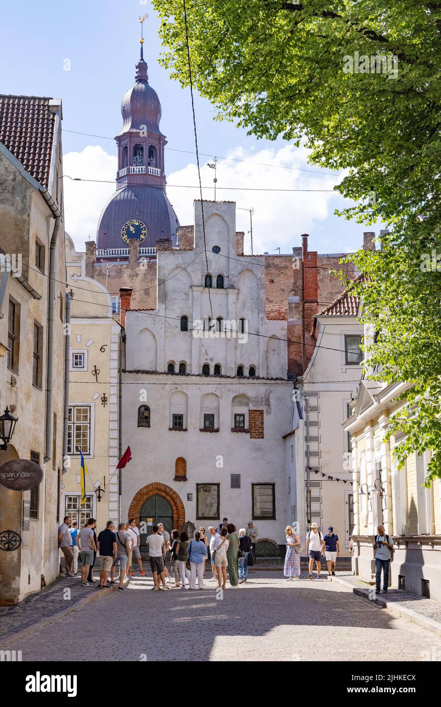 Riga Street scene; turisti presso le tre case Fratelli guardando al numero 17, un edificio medievale del 15th ° secolo, riga Centro storico, riga Lettonia in estate Foto Stock