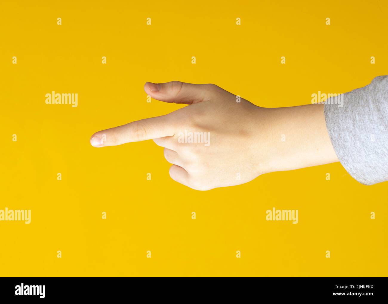 Il gesto della mano femminile mostra un indice da un dito all'altro su sfondo giallo isolato Foto Stock