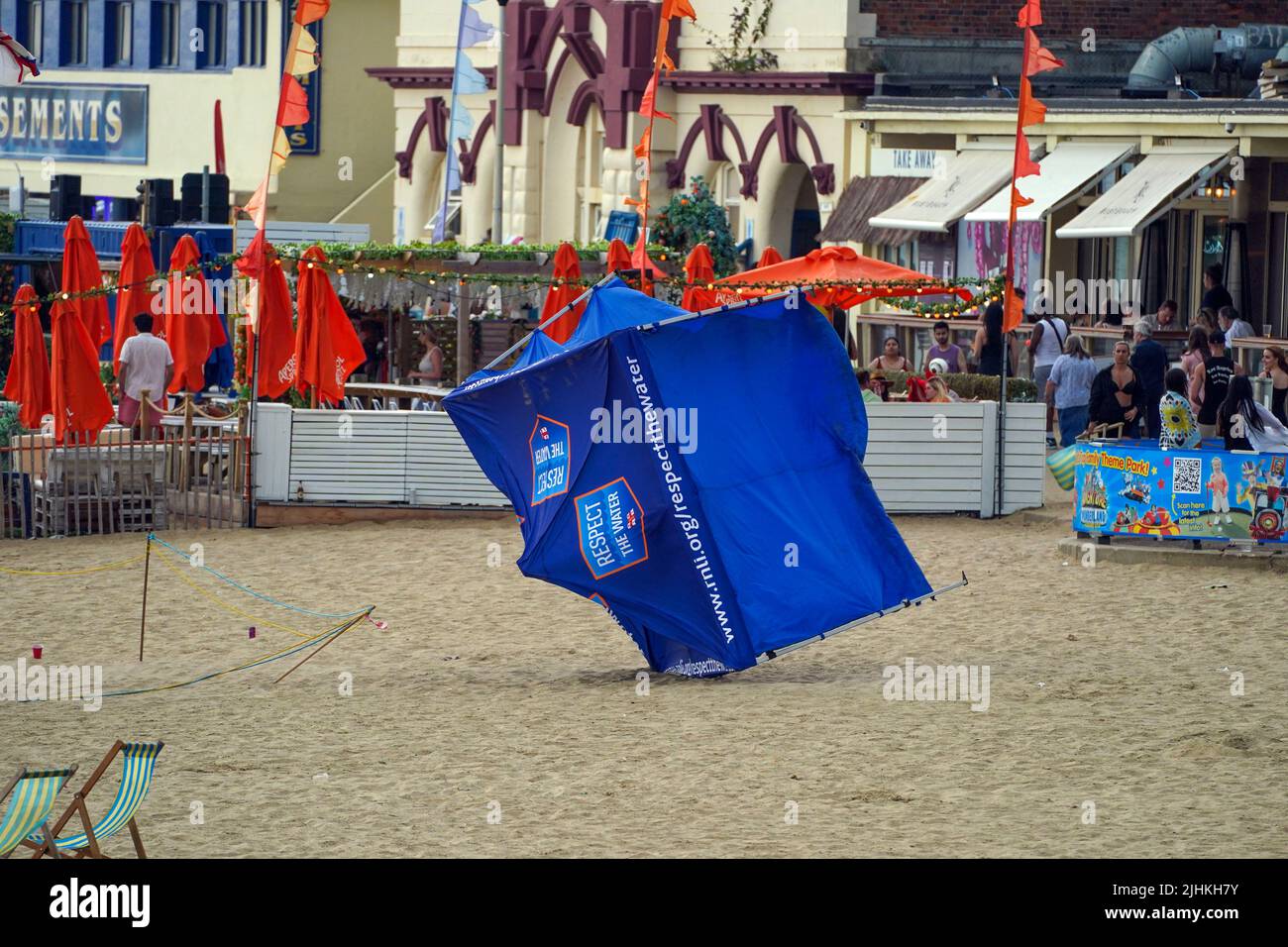 Gli oggetti sono soffiato dai venti mentre le persone si siedono sulla spiaggia di Bournemouth. Le temperature hanno raggiunto i 40C per la prima volta record nel Regno Unito, con 40,2C registrati provvisoriamente a Londra Heathrow, ha detto il MET Office. Data foto: Martedì 19 luglio 2022. Foto Stock