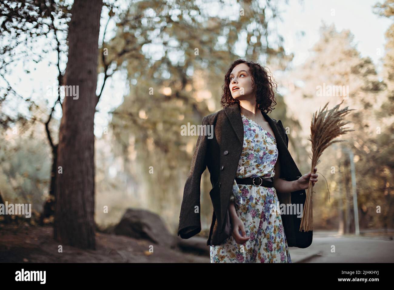 Lifestyle ritratto di vintage vestito giovane donna con bouquet di erba secca a piedi nel parco autunnale Foto Stock