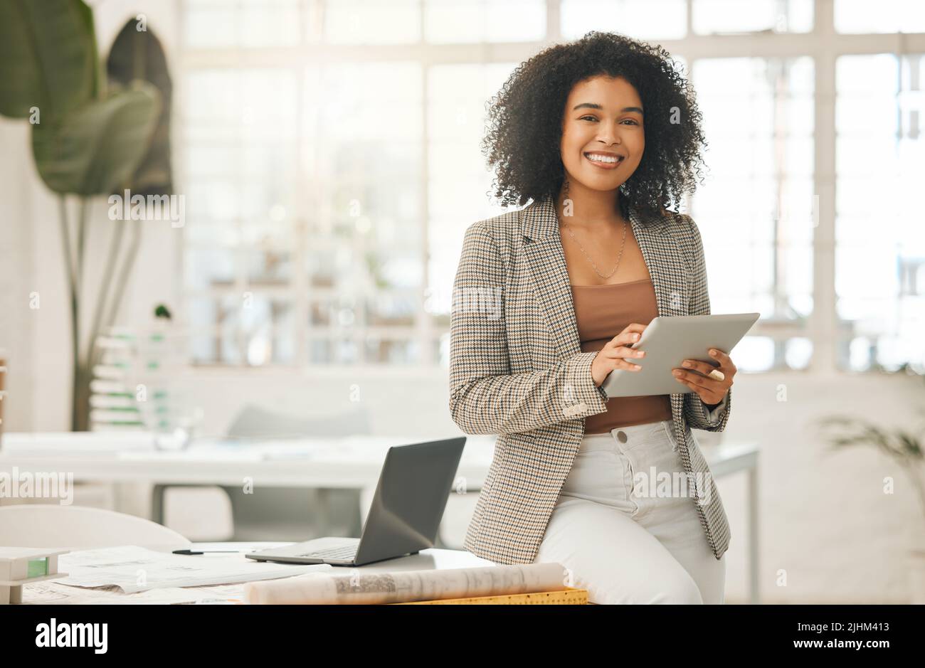 Una donna d'affari felice che usa un tablet digitale. Giovane donna d'affari leader che utilizza un tablet wireless. Designer creativo che lavora nella sua agenzia. Designer Foto Stock