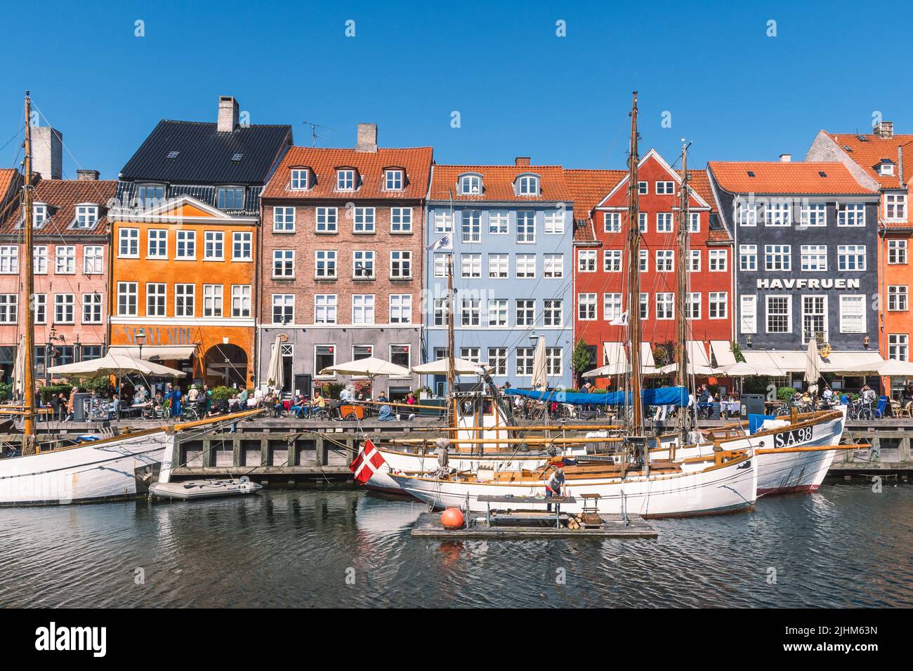 Bella vista con la facciata colorata di case tradizionali e vecchie navi di legno, barche da crociera lungo il canale Nyhavn o New Harbour Foto Stock