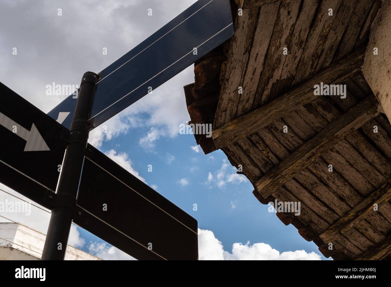 strada segno cielo blu nuvole vecchio soffitto direzioni Foto Stock