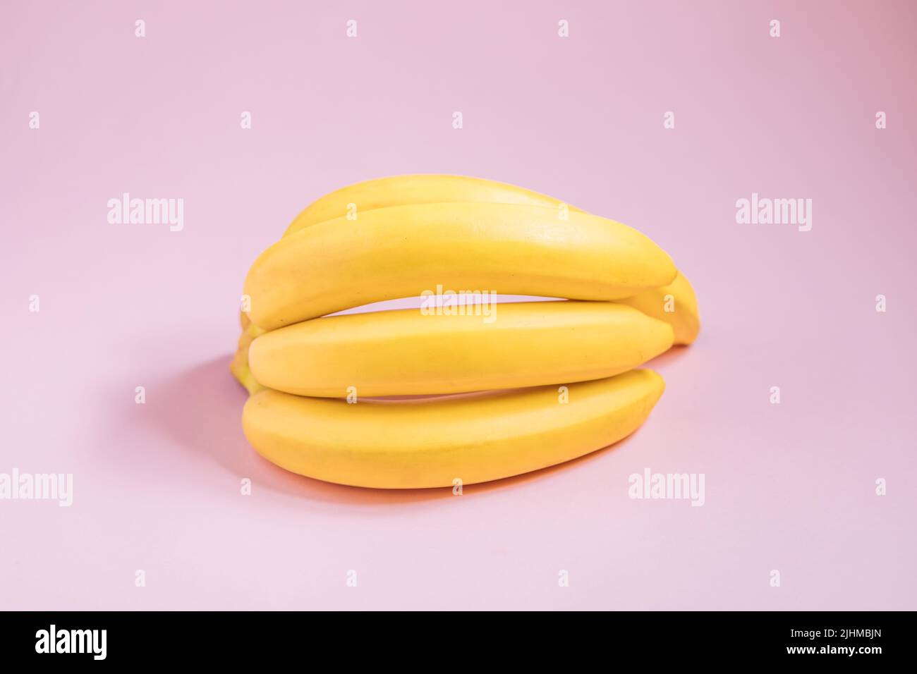 Banana e yogurt in vetro su bordo azzurro con banana sullo sfondo. Colazione sana. Dolce. Stile di vita fitness. Dessert vegetariano sano. Foto Stock