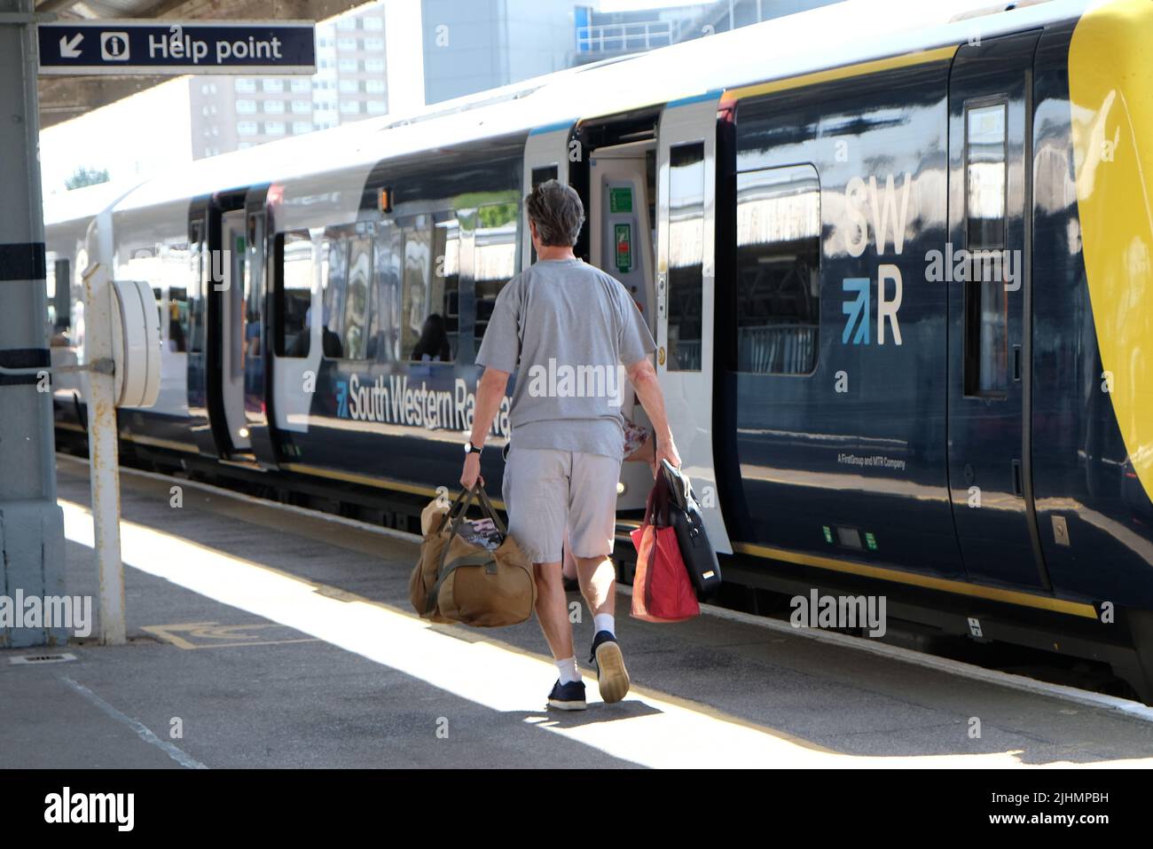 Portsmouth, Regno Unito, 19th luglio 2022. I vacanzieri e i pendolari della stazione di Portsmouth Harbour salirono a Londra e in altre destinazioni, in quanto Network Rail non emettette alcun avviso di viaggio per i servizi diretti a nord della capitale in mezzo alle alte temperature, che si preannunciavano essere il giorno più caldo di sempre. Credit: Undicesima ora Fotografia/Alamy Live News Foto Stock