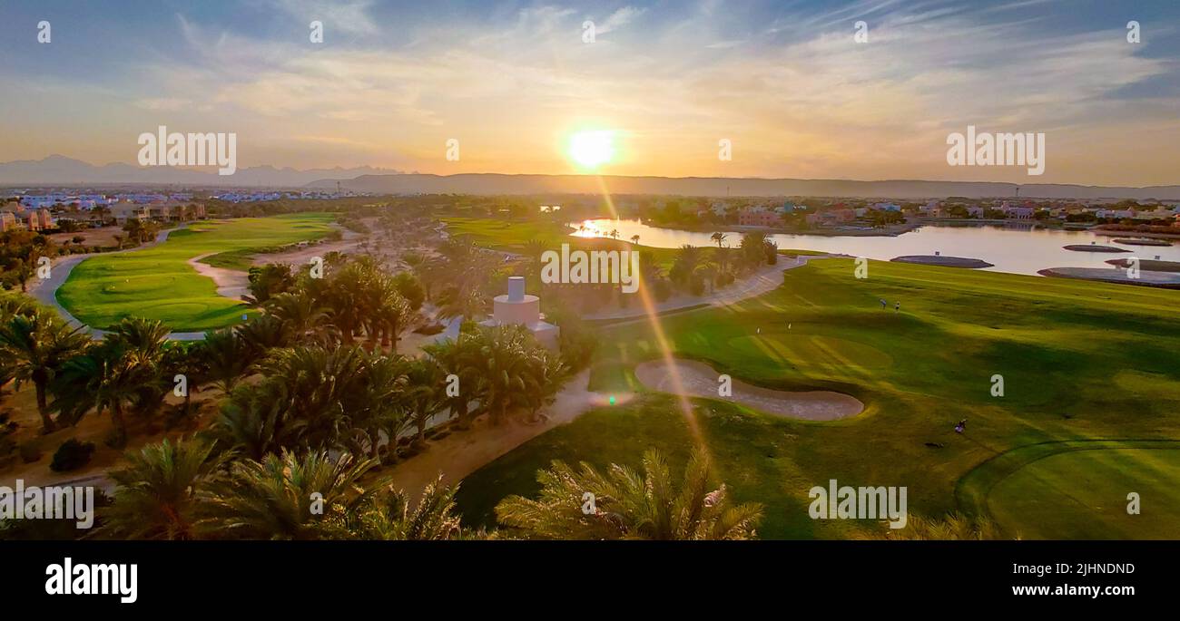 Campo verde con il colorato cielo al tramonto - mostrando i colori sorprendenti del cielo al tramonto Foto Stock