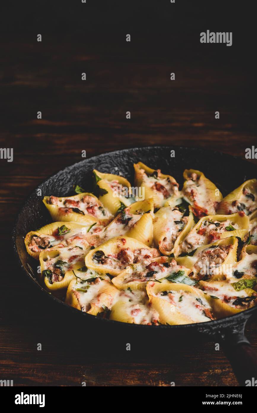 Pailletto di conchiglie di jumbo al forno farcite con manzo macinato, spinaci e formaggio Foto Stock