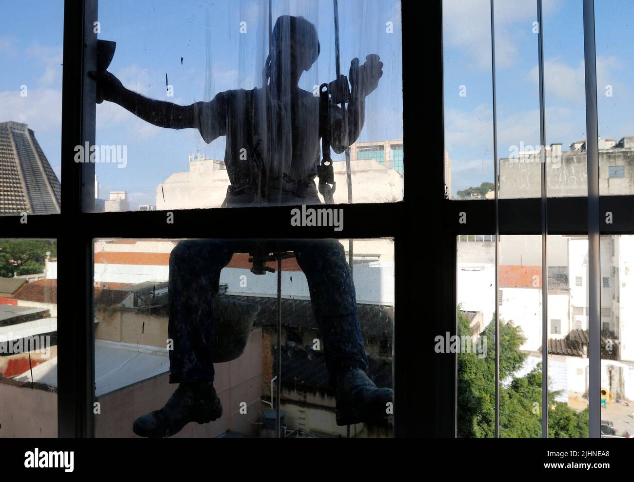 Rappeling uomo lavoro sul servizio di pulizia di finestre esterne e riparazione di edifici. Lavoro rapel ristrutturazione edificio. Carpentiere di costruzione lavoratore Foto Stock