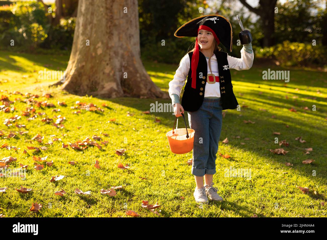 Immagine di felice ragazzo caucasico in costume da pirata nel giardino d'autunno Foto Stock