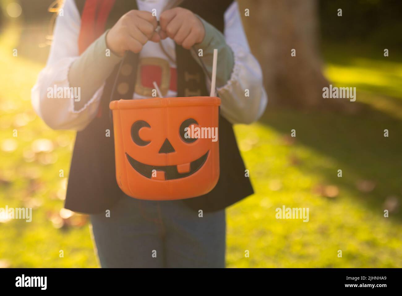 Immagine della sezione media del ragazzo caucasico in costume da pirata nel giardino d'autunno Foto Stock