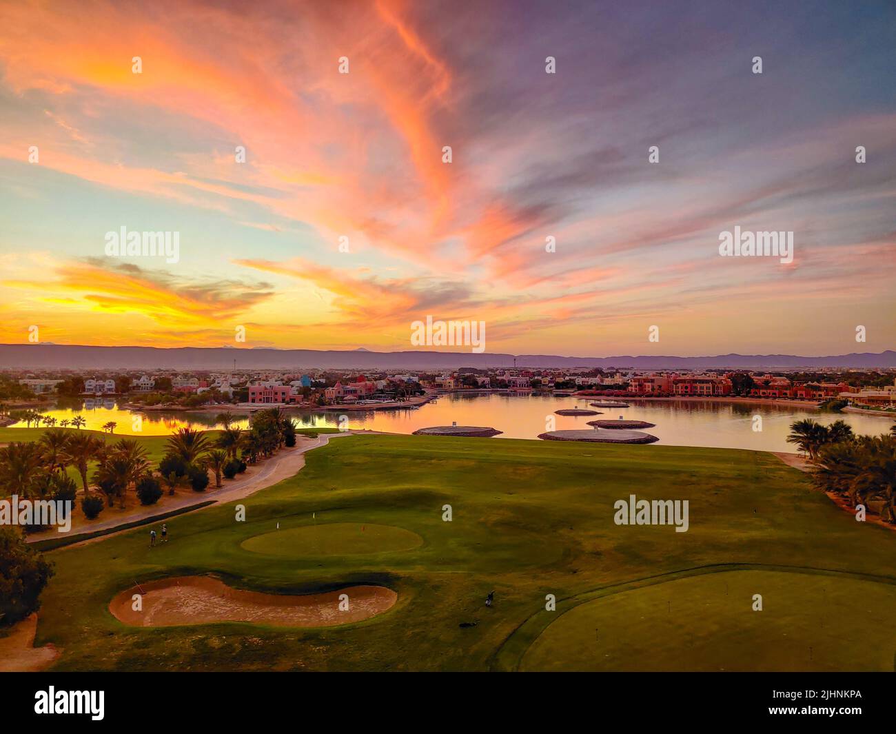 Campo verde con il colorato cielo al tramonto - mostrando i colori sorprendenti del cielo al tramonto Foto Stock