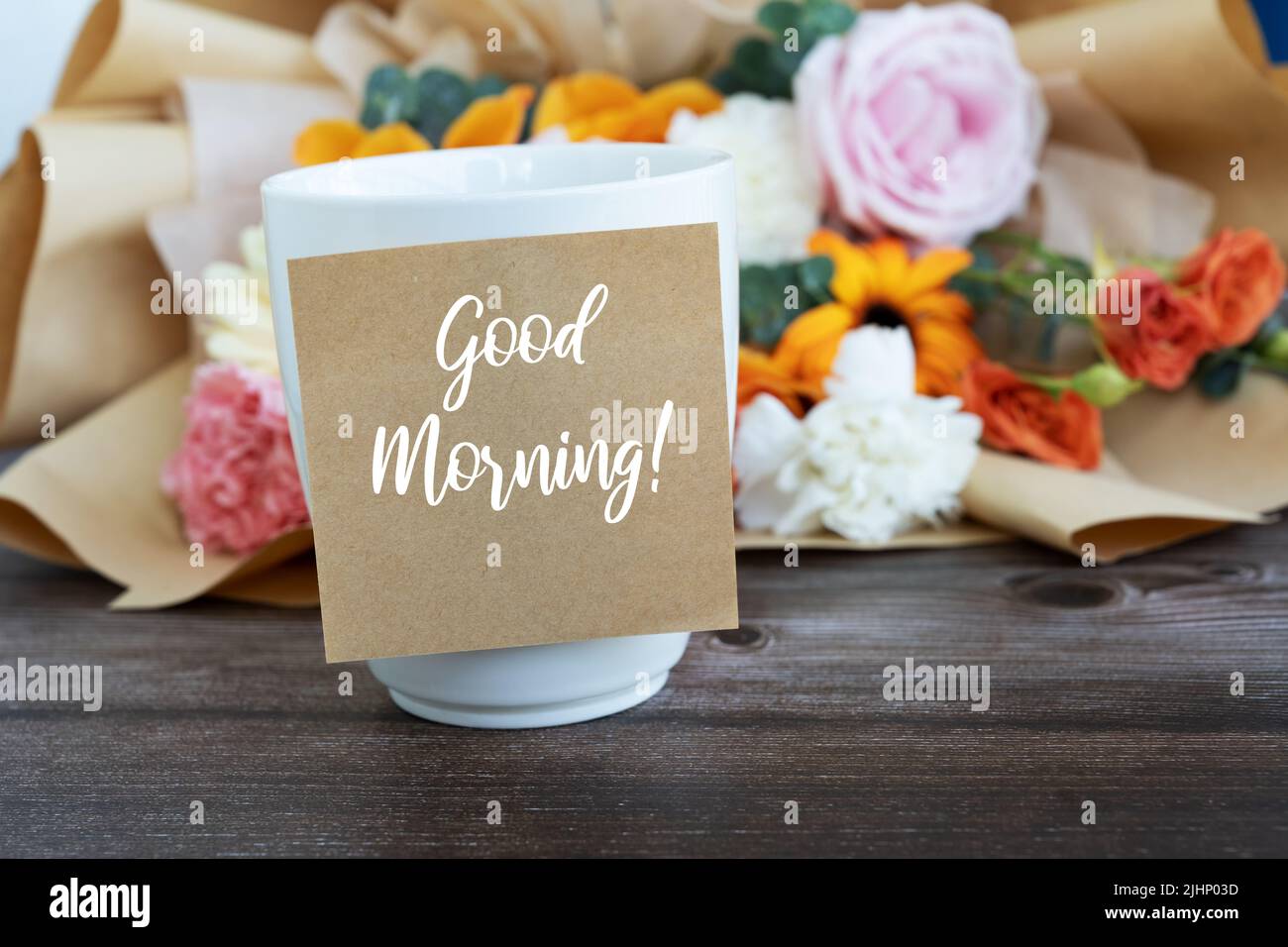 Buona mattina saluto su nota adesiva con tazza di caffè e fiore Foto Stock