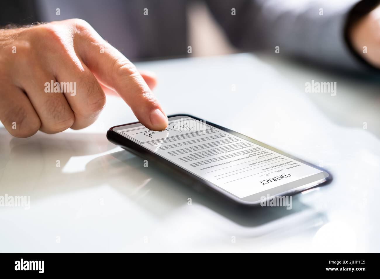 Firma digitale sul documento contrattuale online utilizzando lo smartphone Foto Stock