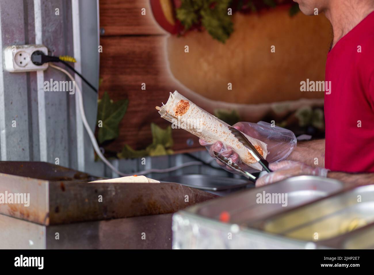 Mani di uno chef professionista che fa Shawarma in un ristorante arabo Foto Stock