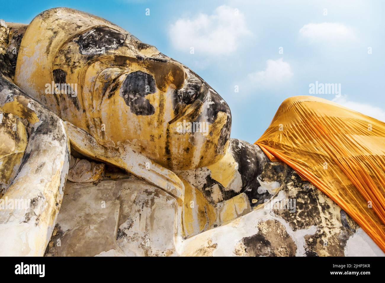 Statua del Buddha reclinata in abiti di safran festosi da vicino a Wat Lokaya Sutharam in Ayuttaya, Thailandia. Statua di Buddha sdraiata Foto Stock