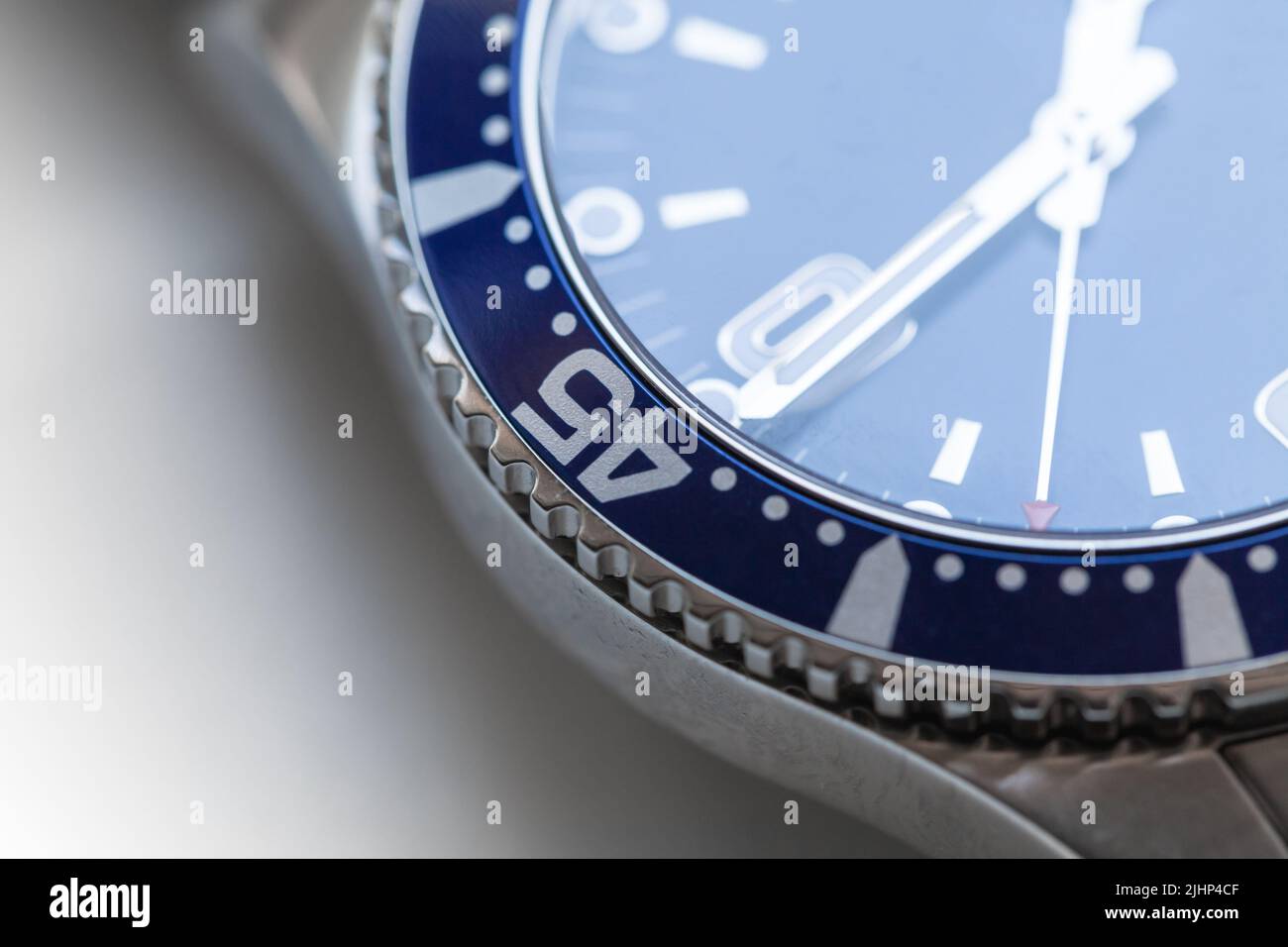 Orologio meccanico automatico svizzero da polso frammento con rivestimento blu e cornice in ceramica rotante. Foto primo piano con soft focus selettivo Foto Stock