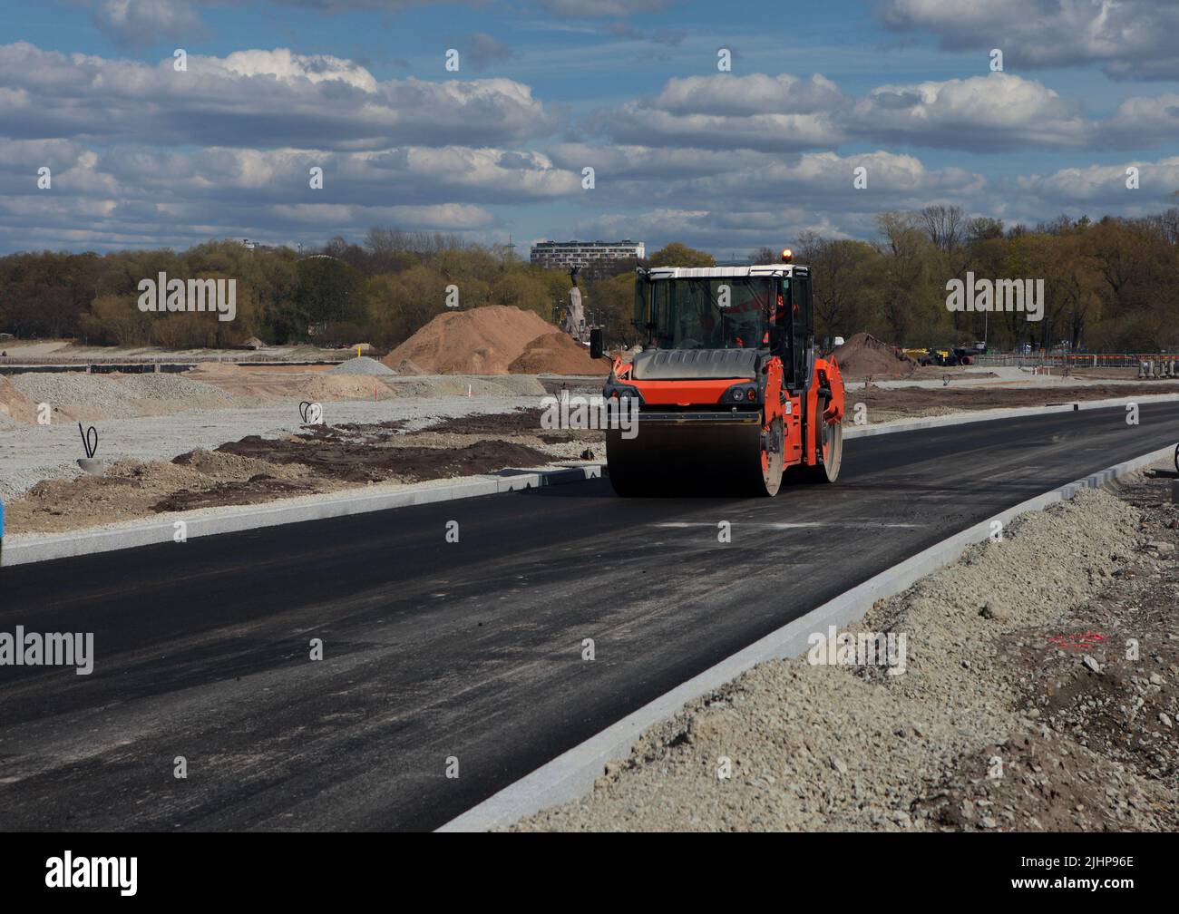 Rullo che rotola asfalto caldo fresco sulla nuova strada. Costruzione di strade. Foto Stock