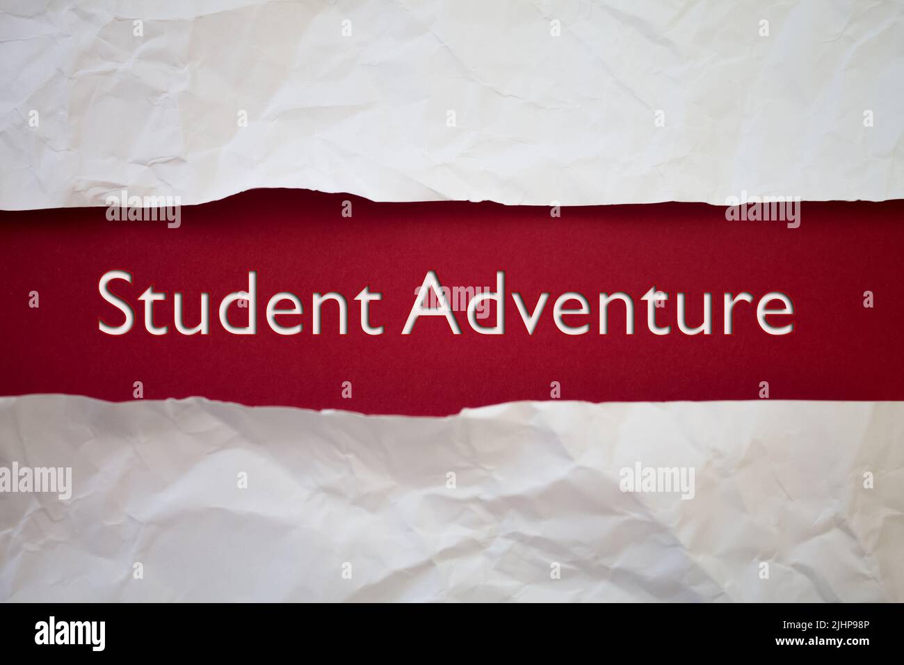 Testo dell'Avventura degli studenti con carta bianca strappata e sbriciolata su sfondo colorato. Foto Stock