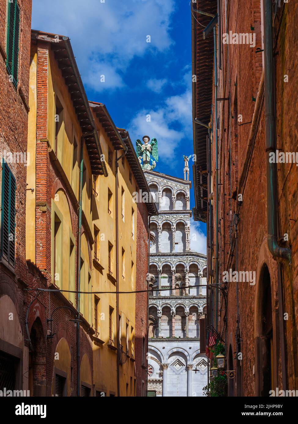 Vista di Lucca affascinante centro storico strada stretta con la bella chiesa medievale di San Michele Foto Stock