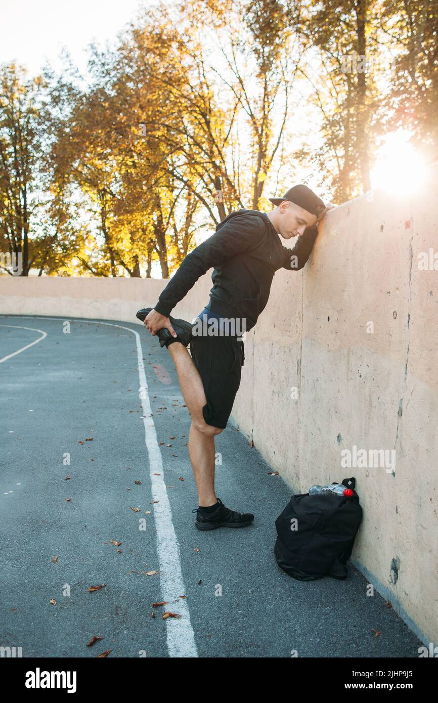 Primo piano dell'atleta che si estende vicino alla parete Foto Stock