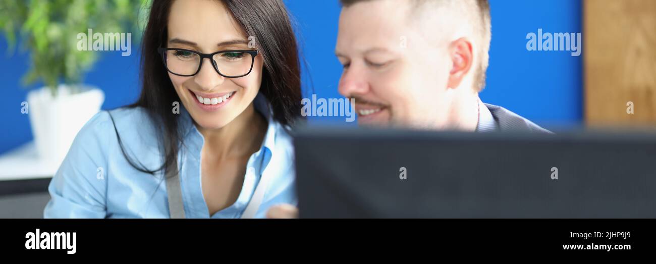 I lavoratori uomini e donne in carica discutono qualcosa e ridono Foto Stock