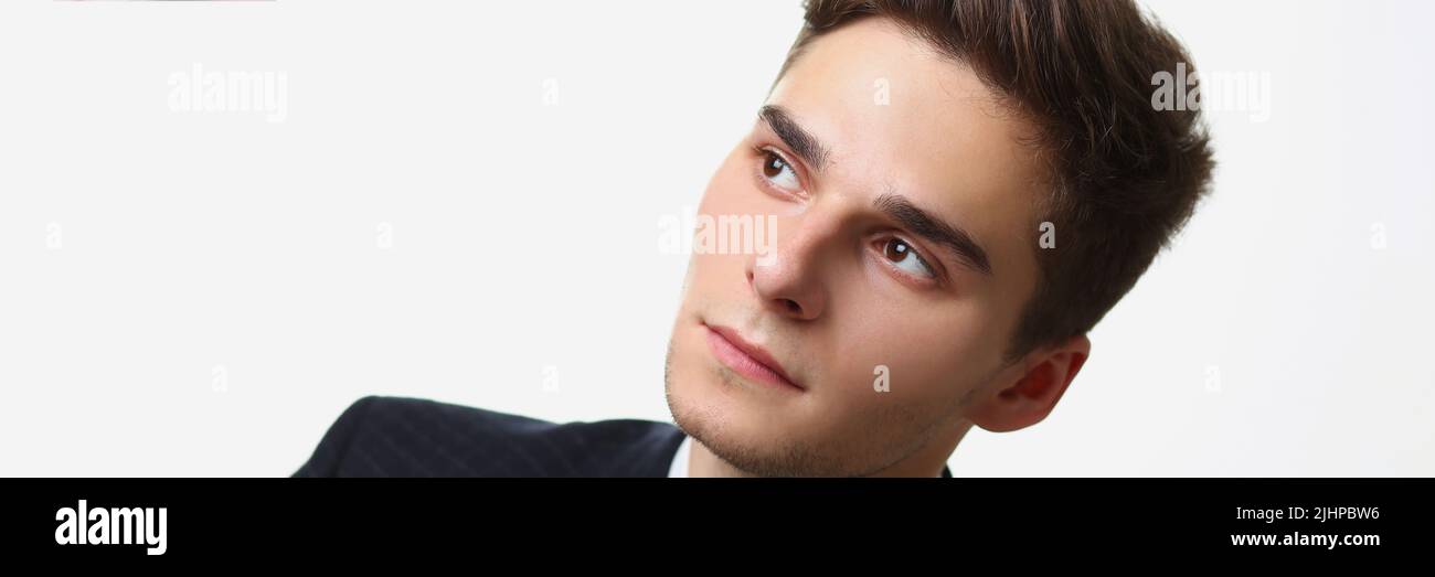 Bel giovane che guarda via, aspetto pensivo, umore premuroso Foto Stock