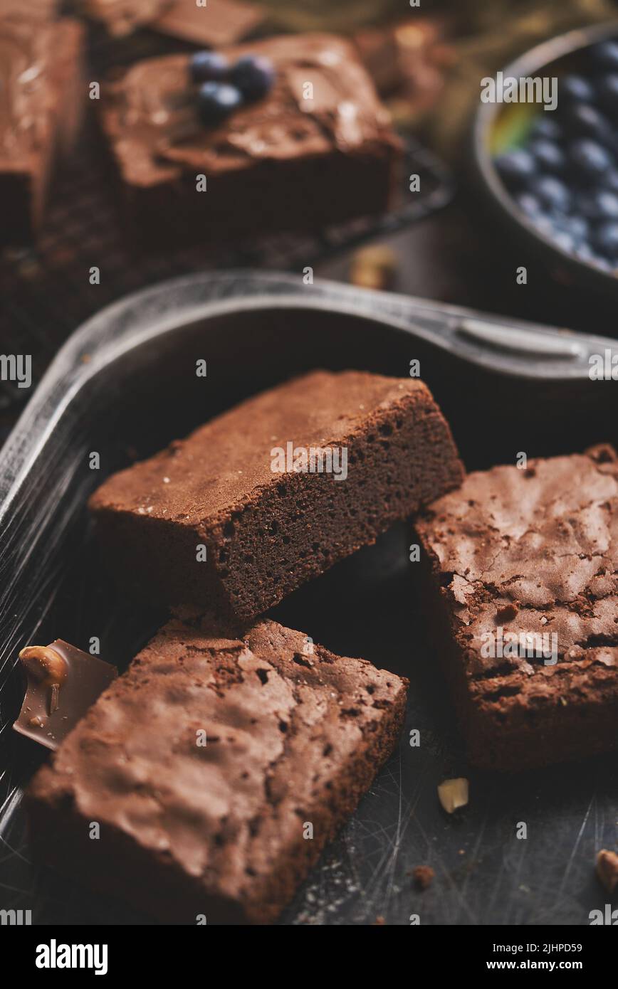 Composizione di quadrati di brownie al cioccolato fatti in casa freschi che fondono cioccolato e mirtilli freschi Foto Stock