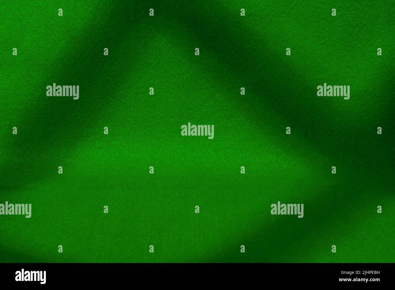 Scena coperta in feltro verde scuro con ombre profonde. Texture e sfondo con spazio di copia Foto Stock