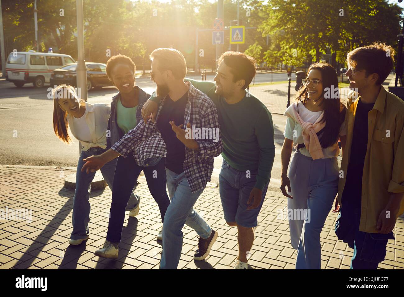 Il goup di amici allegri cammina per le strade della nuova città insieme durante le vacanze del fine settimana. Foto Stock