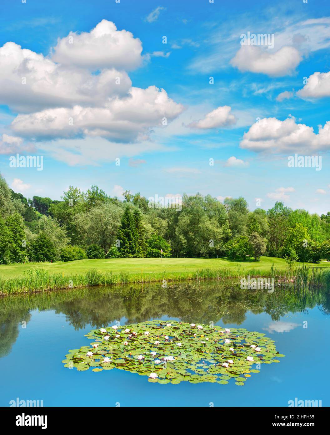 Campo da golf campo verde con lago e bellissimo cielo blu. Il paesaggio europeo Foto Stock