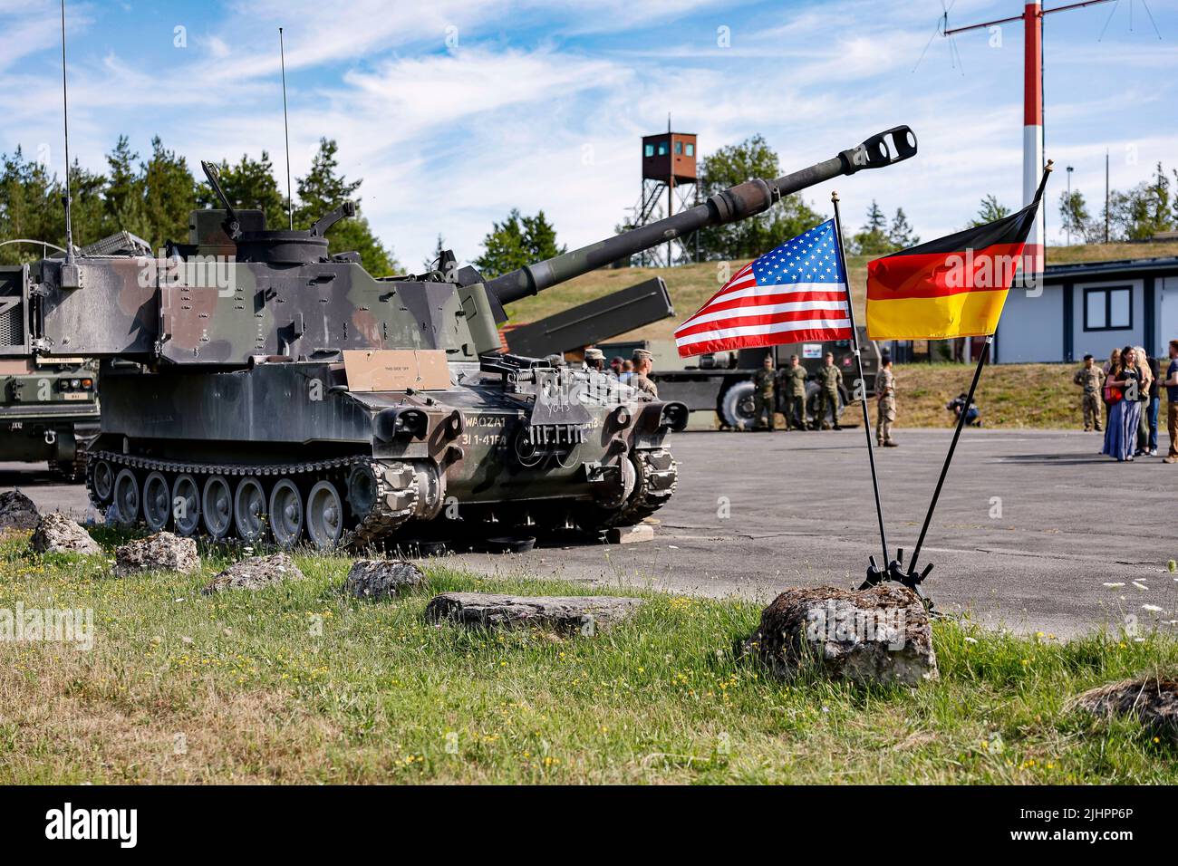 20 luglio 2022, Baviera, Grafenwöhr: Un carro armato di Paladin degli Stati Uniti si trova dietro due bandiere degli Stati Uniti e della Germania durante un'esercitazione multinazionale dell'artiglieria degli Stati Uniti che coinvolge quasi 2.400 soldati da 19 nazioni all'area di addestramento di Grafenwoehr in Baviera. Foto: Daniel Löb/dpa Foto Stock