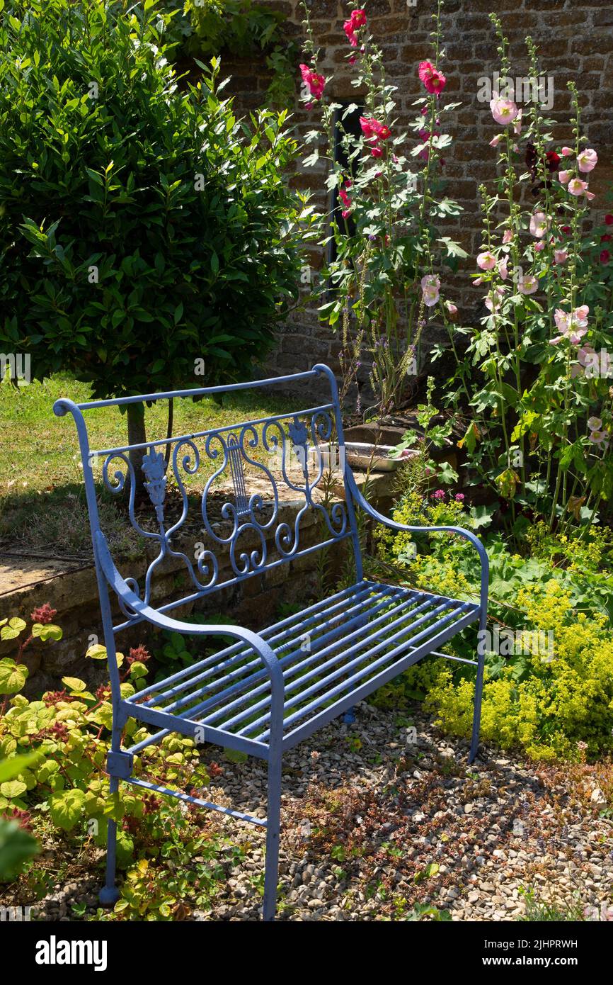 Panca da giardino in metallo in giardino inglese, Inghilterra Foto Stock