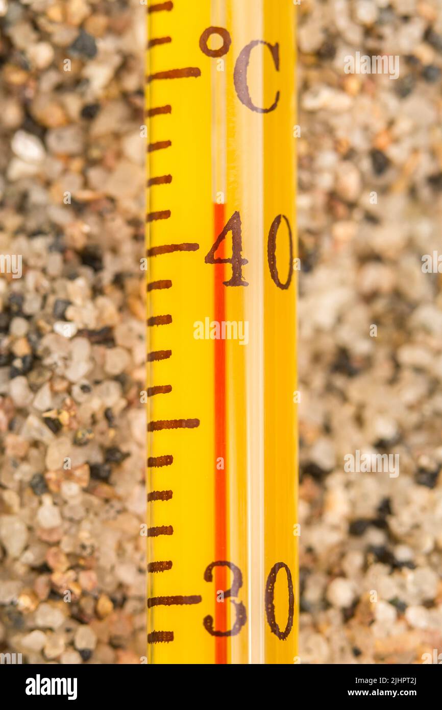 Termometro con alcool in vetro in primo piano su sabbia grossolana, lettura 40 C. per l'onda termica estiva 2022, onda termica UK, tempo caldo, alte temperature, calore grave Foto Stock