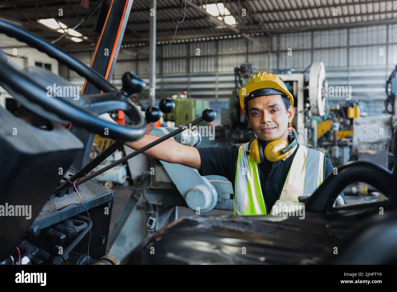 L'ingegnere asiatico si prepara a guidare il carrello elevatore nell'industria Foto Stock