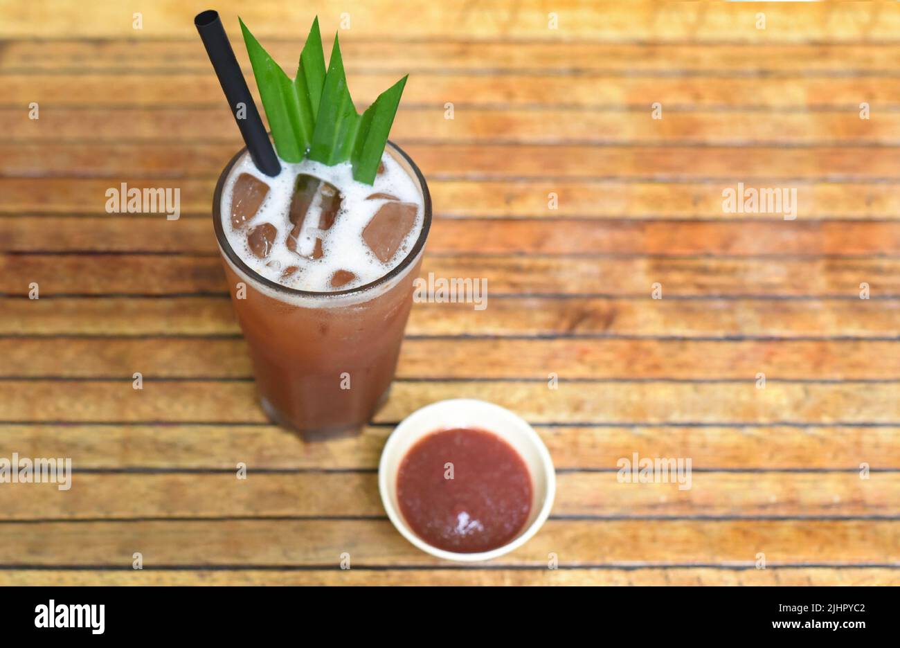 Tè ghiacciato di susina con marmellata su sfondo di tavole di legno Foto Stock