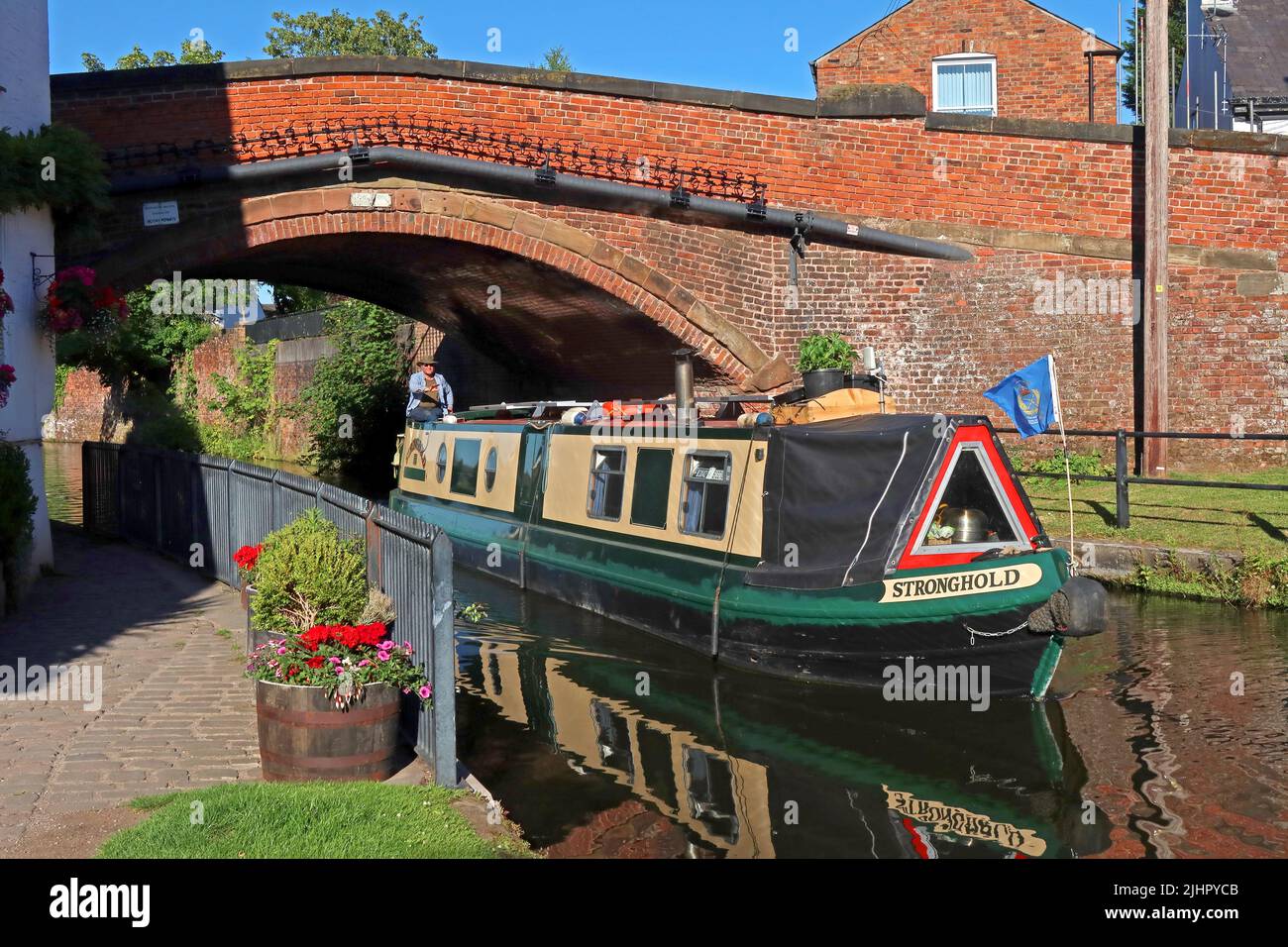 Bridgewater Canal Barge al Lymm Village, vela sotto il ponte, Warrington, Cheshire, Inghilterra, Regno Unito - roccaforte Foto Stock