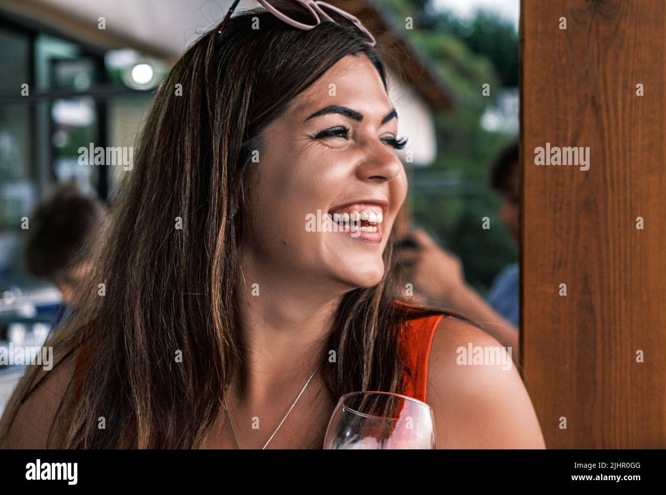 Ritratto vista laterale di una bella bruna sorridente giovane abbronzata. Una donna ragazza felice guarda in lontananza e ride sinceramente. Gioia, piacere da Foto Stock