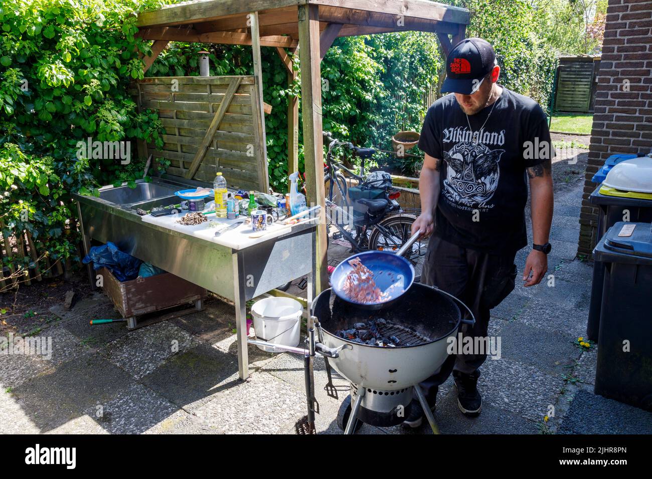 Outdoor-Cooking mit Zanderfillets in der Pfanne auf dem Holzkohlegrill Foto Stock