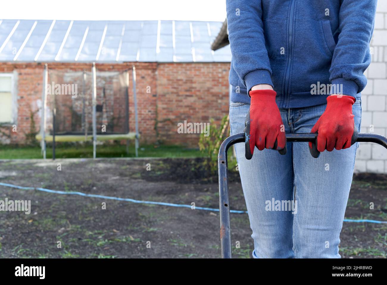 Foto ritagliata di una persona che appiattisce un pezzo di terra Foto Stock