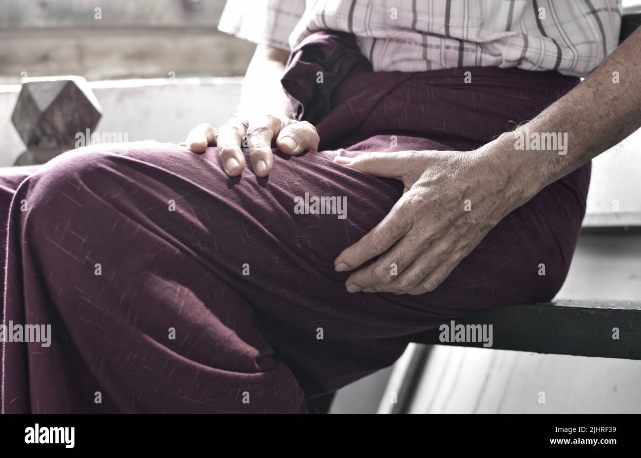 Dolore alla coscia in pazienti maschi anziani asiatici. Concetto di sciatica o dolore nervoso sciatico. Foto Stock