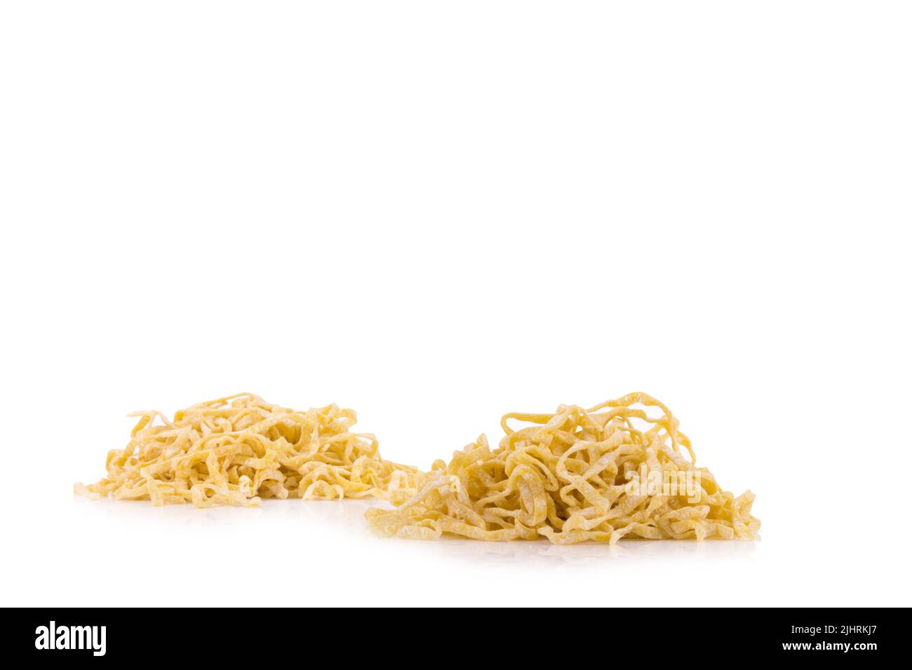 Spaghetti gialli che asciugano isolati su sfondo bianco. Foto Stock