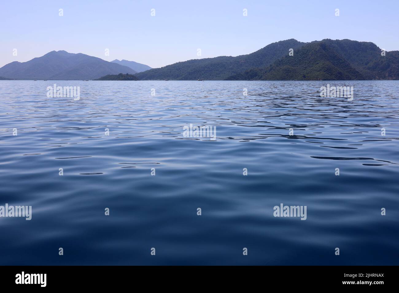Vista sul mare blu e sulle verdi isole di montagna all'orizzonte. Acque profonde, sfondo per viaggi e vacanze Foto Stock