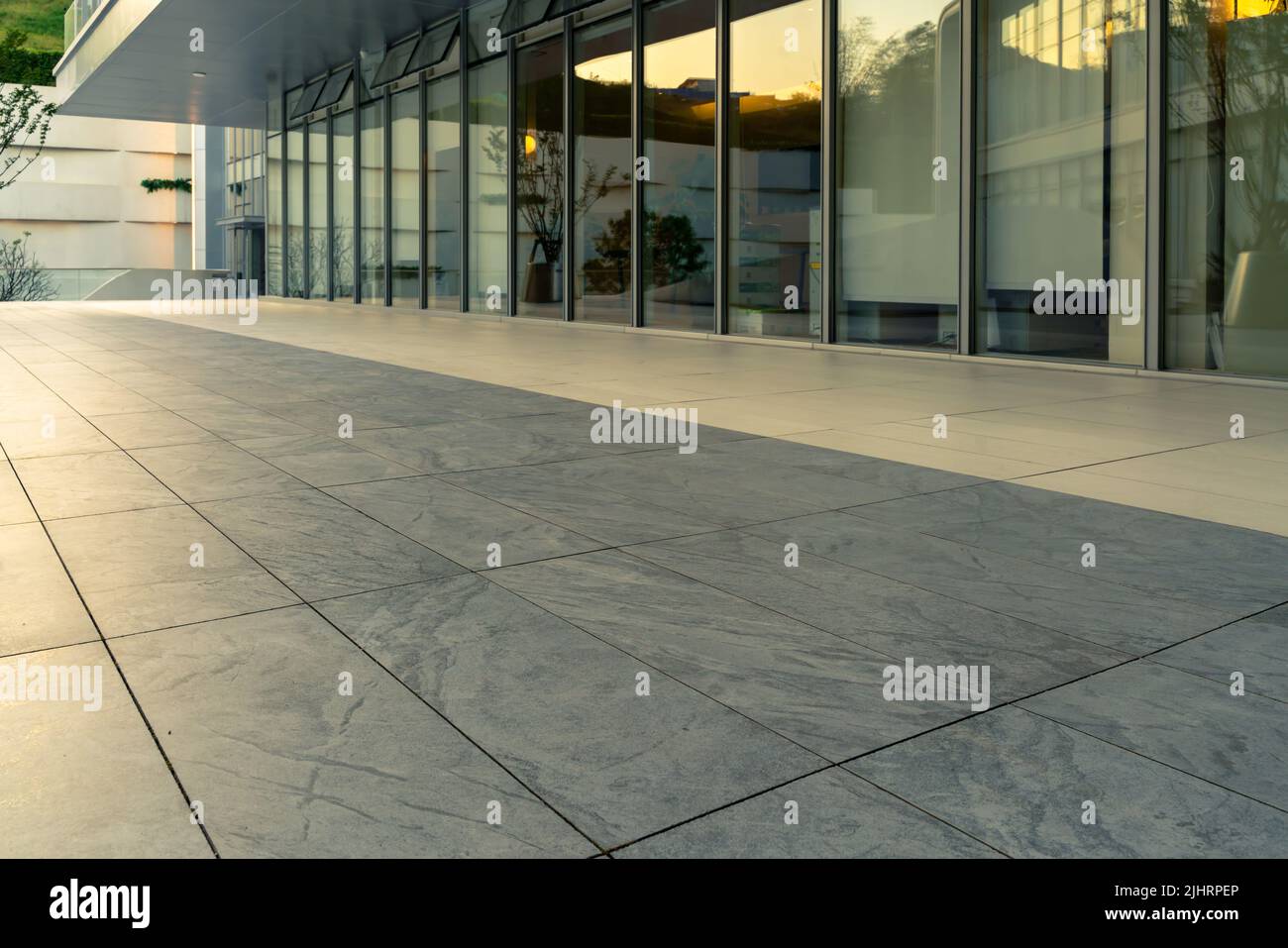 Il piano terra in marmo vuoto di fronte all'esterno del moderno edificio degli uffici Foto Stock