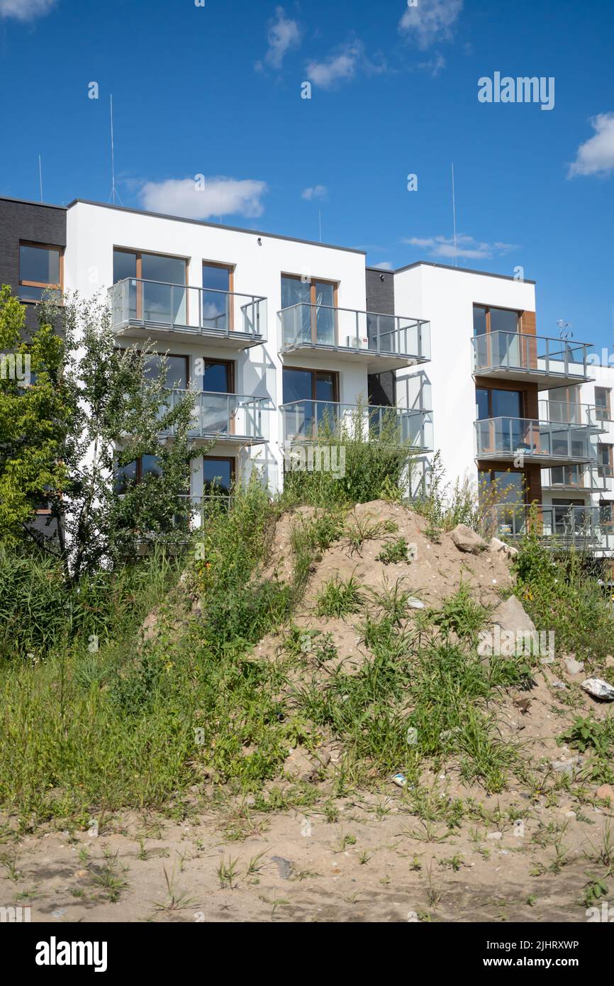 Collina di sabbia di fronte ad un edificio di appartamenti in una giornata di sole Foto Stock