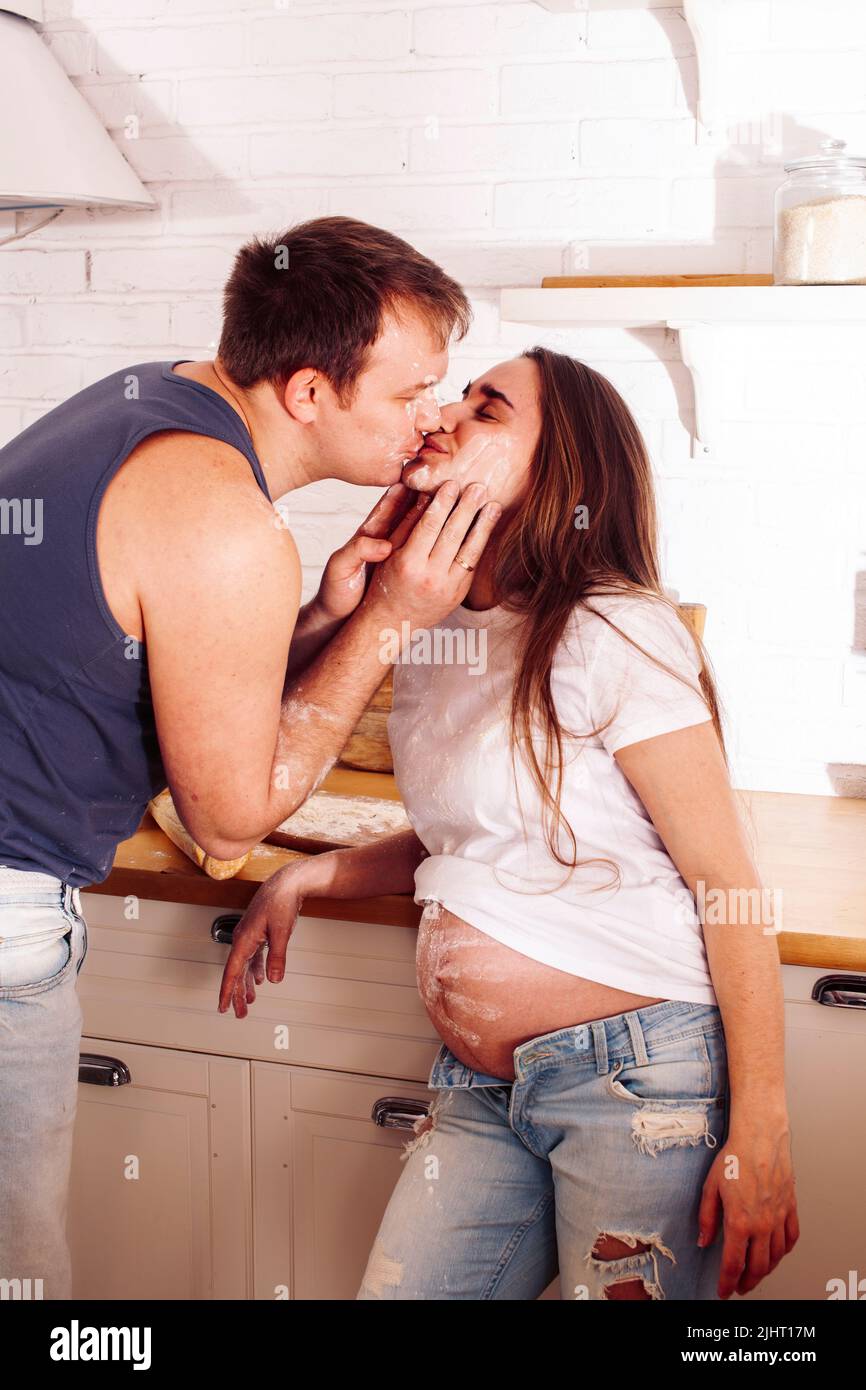 giovane coppia caucasica insieme divertirsi in cucina, donna incinta, stile di vita persone concetto Foto Stock