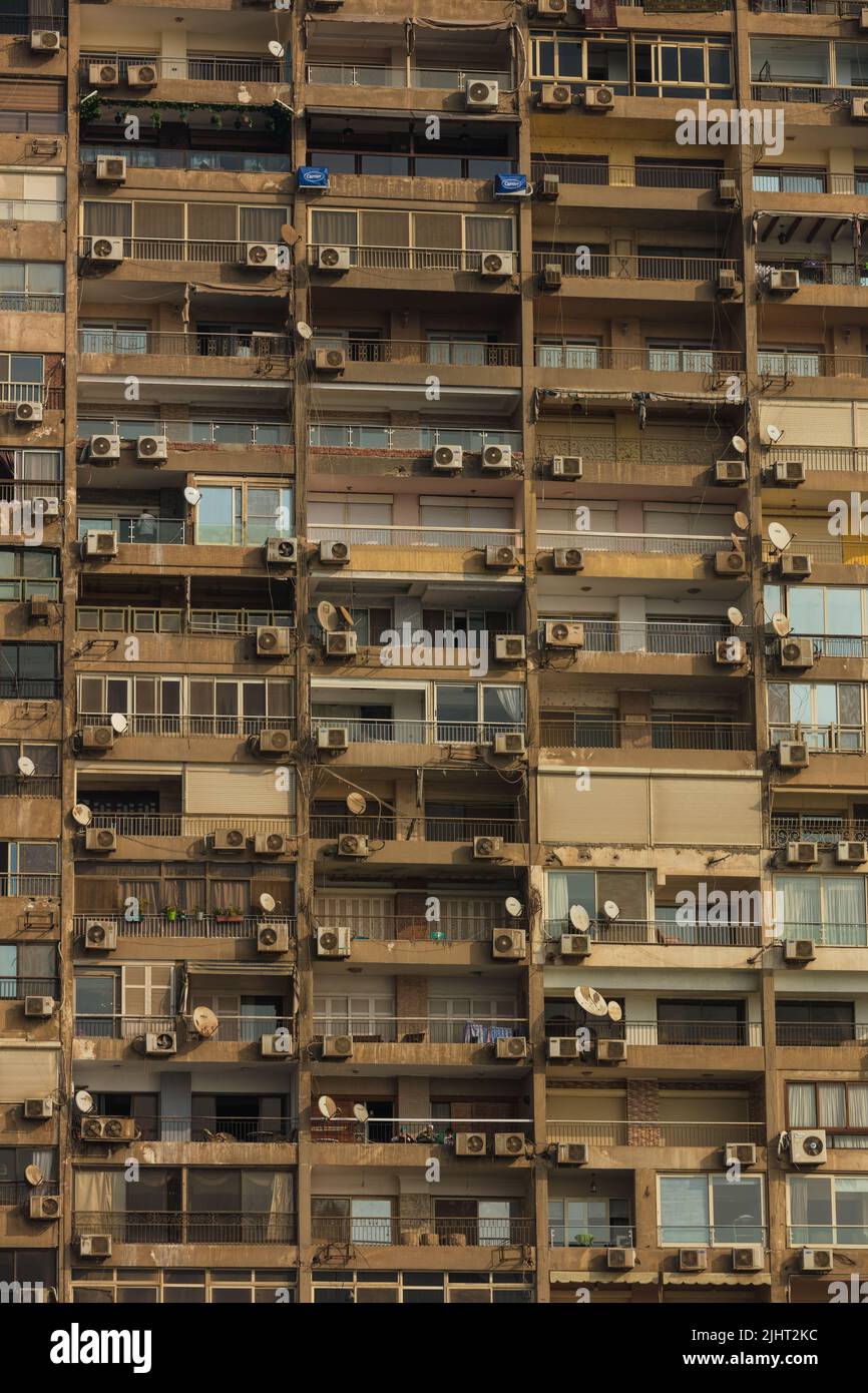 Finestre quadrate grigie di un grattacielo di un moderno edificio cittadino. Moderni appartamenti in una zona densamente popolata del Cairo. Finestre di costruzione Foto Stock