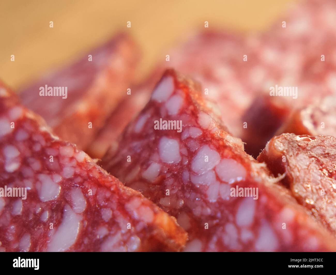 Pezzi di salsiccia di salame, macrofotografia. Delizioso antipasto di carne. Foto Stock