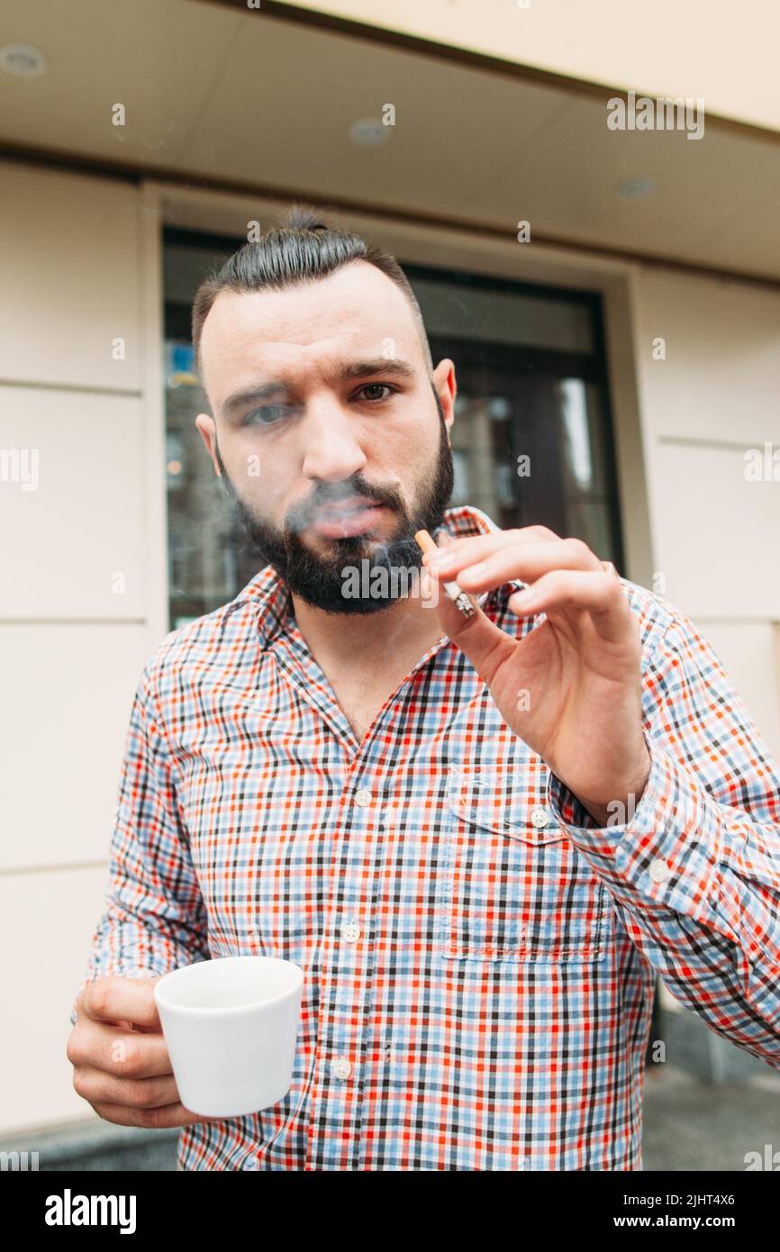 Hipster cocky con ritratto di caffè e sigaretta Foto Stock